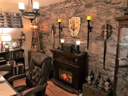 Castle Stone Wallpaper, as seen on the wall of this medieval office, features realistic brown stacked stones. Stone wall murals from About Murals.