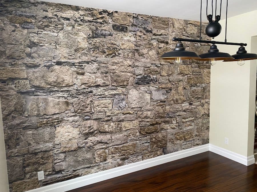 Castle Stone Wallpaper, as seen on the wall of this room behind industrial lighting, is a photo mural of beige stones from About Murals.