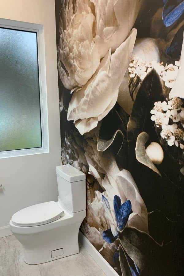 Black Floral Wallpaper, as seen on the wall of this bathroom, is a photo mural of a white peony on a dark background from About Murals.