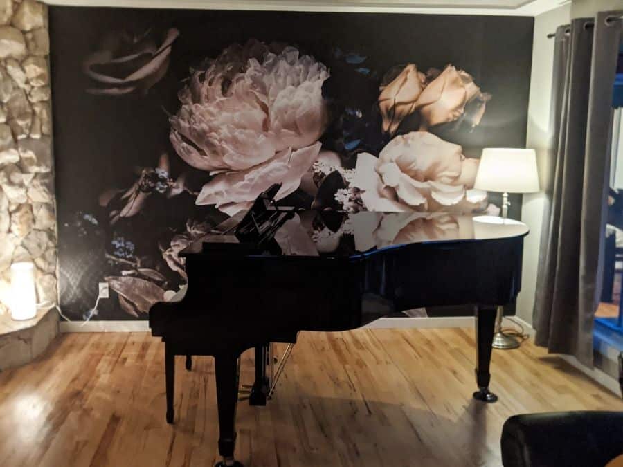 Black Floral Wallpaper, as seen on the wall of this piano room, is a photo mural of cream roses, ivory peonies and blue flowers against a dramatic dark background from About Murals.