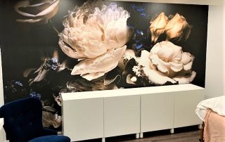 Black Floral Wallpaper, as seen on the wall of this spa, features beautiful rose and peony flowers on a dark background. Floral wallpaper sold by AboutMurals.ca.
