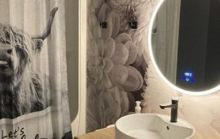 Black and White Flower Wallpaper, as seen on the wall of this bathroom, is a photo wall mural of large beautiful grey dahlia flowers from About Murals.