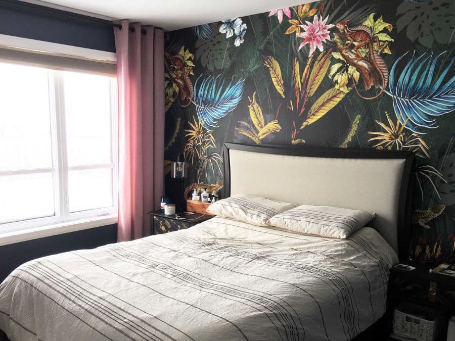 Black Tropical Wallpaper, as seen on the wall of this spare room, is a mural with palm fronds, banana leaves, sultry flowers and lizards on a dark background from About Murals.