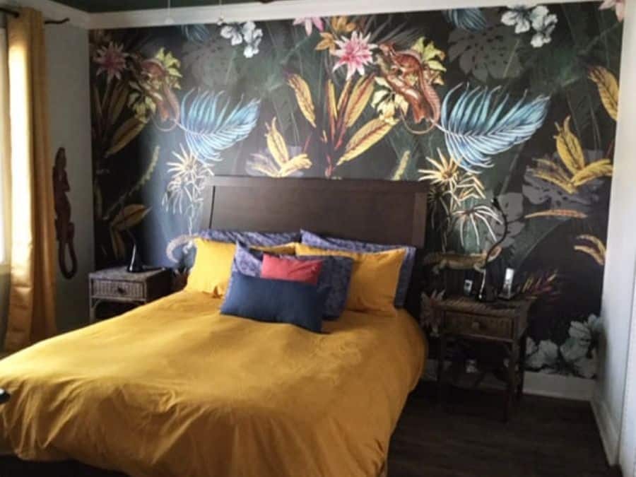 Black Tropical Wallpaper, as seen on the wall of this yellow theme bedroom, is a mural with exotic flowers, leaves and lizards on a dark background from About Murals.