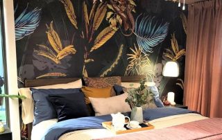 Black Tropical Wallpaper, as seen on this master bedroom wall, features palm fronts, banana leaves, flowers and lizards on a dark background. Tropical wallpaper sold by AboutMurals.ca.