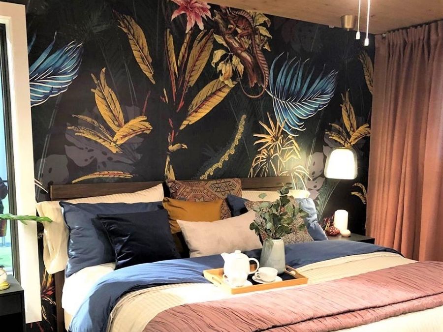 Black Tropical Wallpaper, as seen on this master bedroom wall, features palm fronts, banana leaves, flowers and lizards on a dark background. Tropical wallpaper sold by AboutMurals.ca.