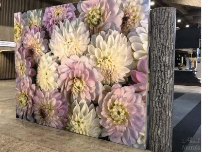 Pink Flower Wallpaper, as seen on the wall at a trade show, features pink and white dahlia flowers. Floral wallpaper sold by AboutMurals.ca.