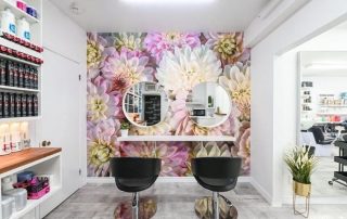 Pink Flower Wallpaper, as seen on the wall of this hair salon, features a closeup of dahlia flowers. Floral wallpaper sold by AboutMurals.ca.