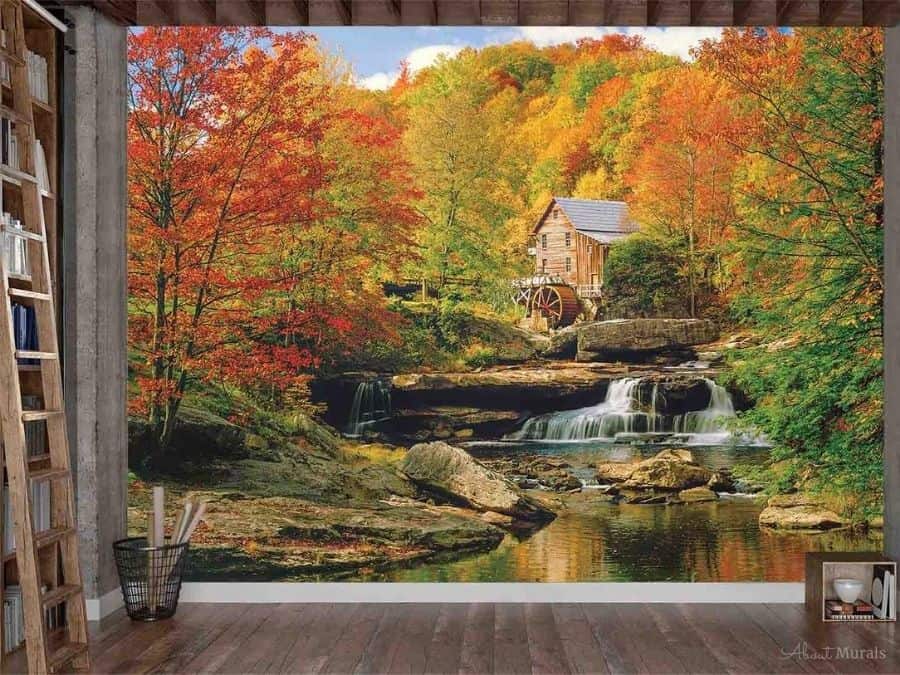 Watermill Wallpaper, as seen on the wall of this office, adds blazing colour and a historic feeling to walls with Glade Creek Grist Mill against fall trees. Autumn forest wallpaper sold by AboutMurals.ca.