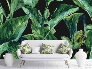 Dark Tropical Wallpaper, as seen on the wall of this living room, is a wall mural with green banana leaves with a watercolor texture on a black background from About Murals.