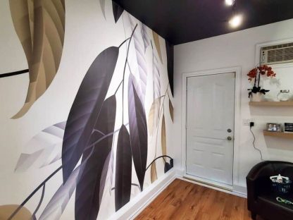Black Grey and Gold Leaf Wallpaper, as seen on the wall of this room, is a mural with large modern foliage on a white background from About Murals.