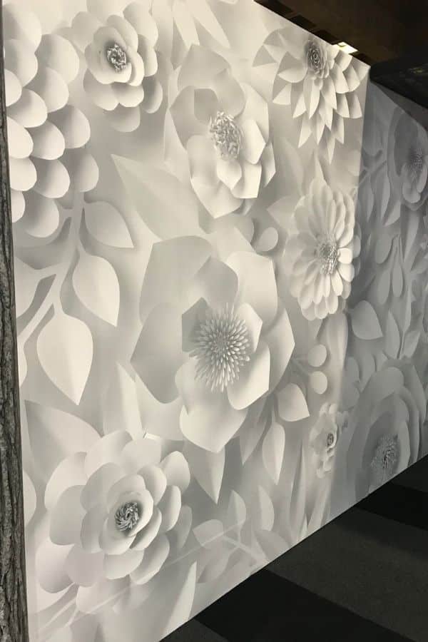 Paper Flower Wallpaper, as seen on the wall of this commercial space, is a white floral wallpaper from About Murals.