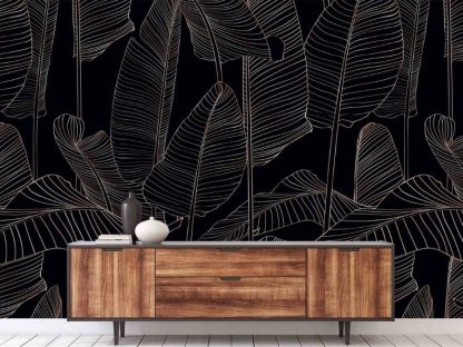 Black and Gold Leaf Wallpaper, as seen on the wall of this living room, features gold banana leaves on a dark background from About Murals.