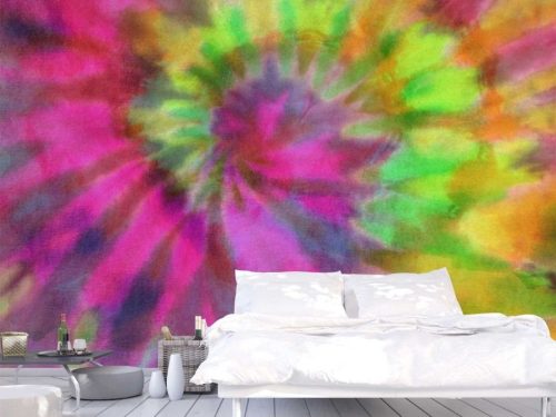 Tie Dye Wallpaper, as seen on the wall of this bedroom, features a pink and green spiral on a fabric texture from About Murals.