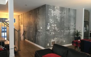 Cracked Concrete Wallpaper, as seen on the wall of this kitchen and entry way, is a realistic, urban design from About Murals.
