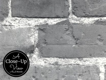 A close-up view of grey bricks and mortar in a black and white brick wallpaper from About Murals.