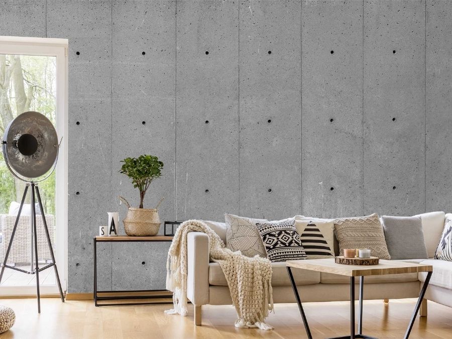 Concrete Wallpaper, as seen on the wall of this living room, is a realistic concrete wall mural complete with tie holes and cement slabs from About Murals.