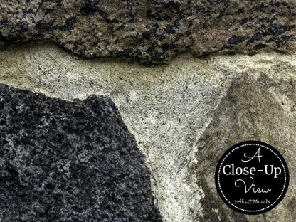 A close-up view of black and grey stones in a dark stone wallpaper from About Murals.