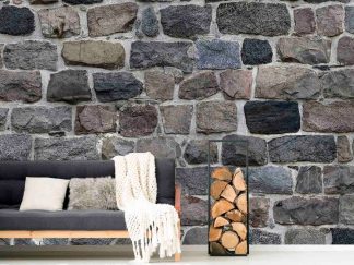 Dark Stone Wallpaper, as seen on the wall of this living room, features realistic grey and black stones that add tons of texture to walls, sold by About Murals.