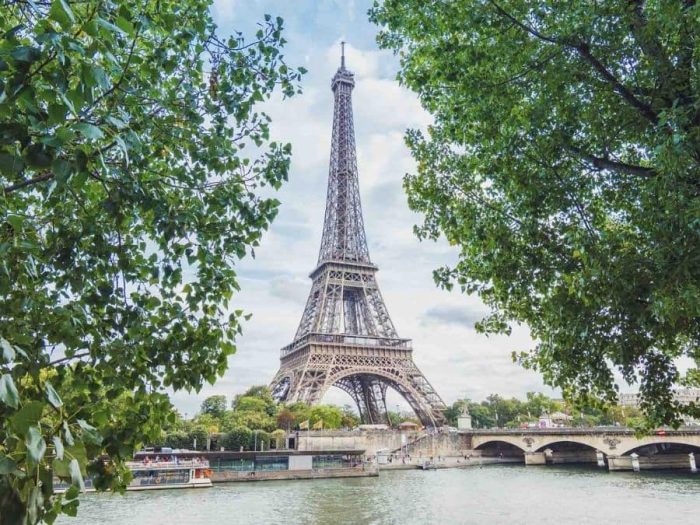 Eiffel Tower Wallpaper is a photo mural of the famous tower overlooking a bridge and river in Paris, France from About Murals.