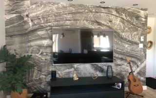 Gray Rock Wallpaper, as seen on the wall of this TV room, is a photo mural of a rock face wall from About Murals.