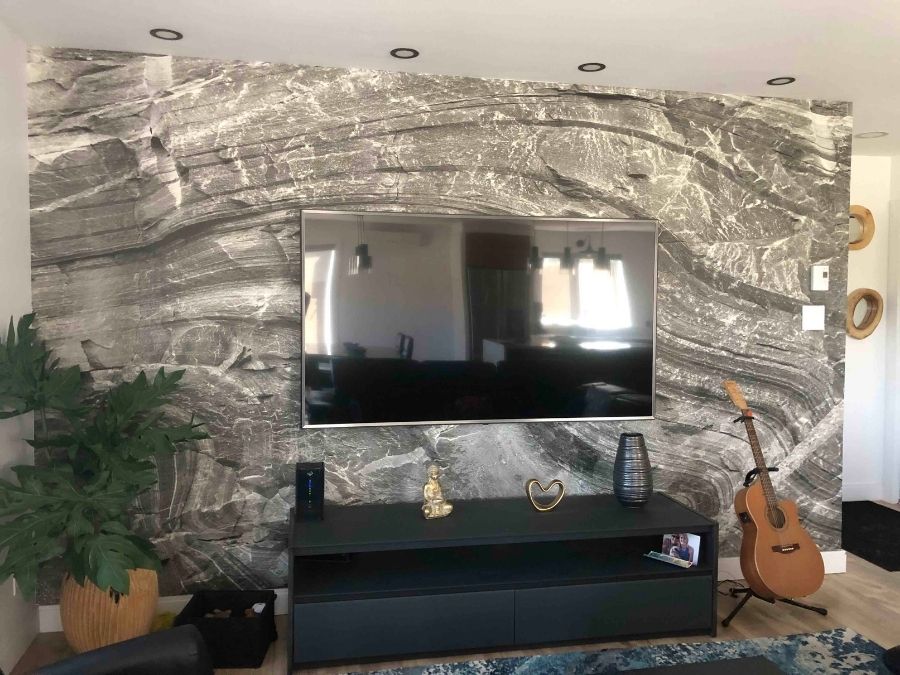 Gray Rock Wallpaper, as seen on the wall of this TV room, is a photo mural of a rock face wall from About Murals.