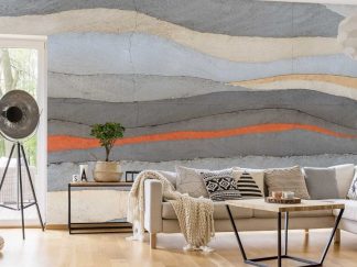 Grey and Orange Concrete Wallpaper, as seen on the wall of this grey and orange living room, is a photo mural of a concrete wall with layers of grey, orange, yellow and light blue from About Murals.