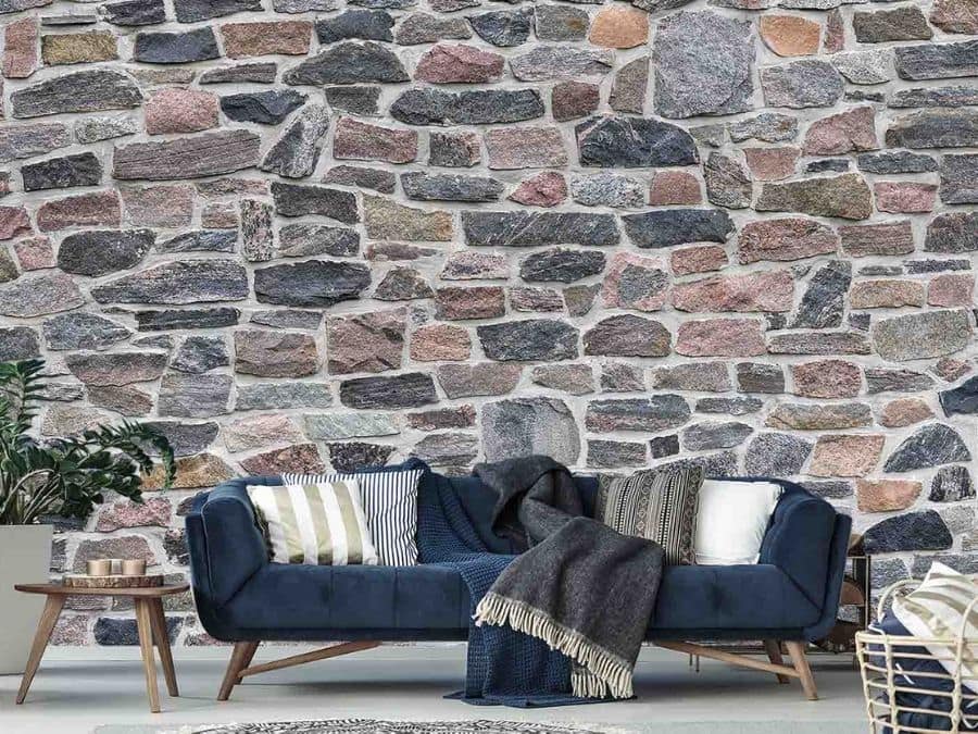 Old Stone Wallpaper, as seen on the wall of this living room, is a photo mural of a real multicolored old stone wall from About Murals.