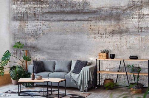 Patina Concrete Effect Wallpaper, as seen on the wall of this living room, is a photo mural of a soft grey and rust colored concrete wall from About Murals.