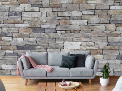 Textured Stone Wallpaper, as seen on the wall of this living room, features a dry stack, grey slate stone wall from About Murals.