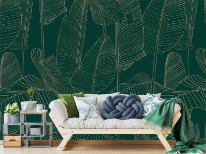 Banana Leaf Wallpaper, as seen on the wall of this living room, is a tropical mural with silhouettes of big leaves in green and gold from About Murals.