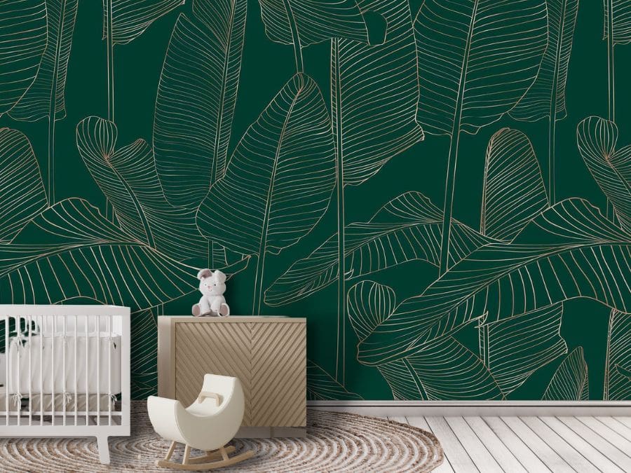 Banana Leaf Wallpaper, as seen on the wall of this nursery, is a tropical wall mural with a gold leaf pattern outlined on a hunter green background from About Murals.