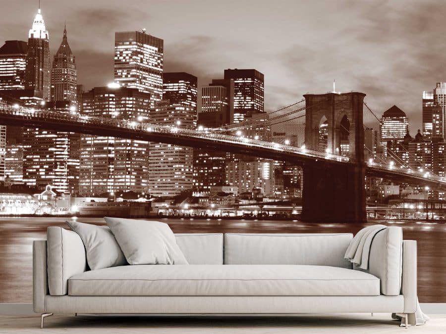 Brooklyn Bridge Park Wallpaper, as seen on the wall of this living room, is a photo wallpaper of the famous suspension bridge lit up with twinkling lights at night from About Murals.