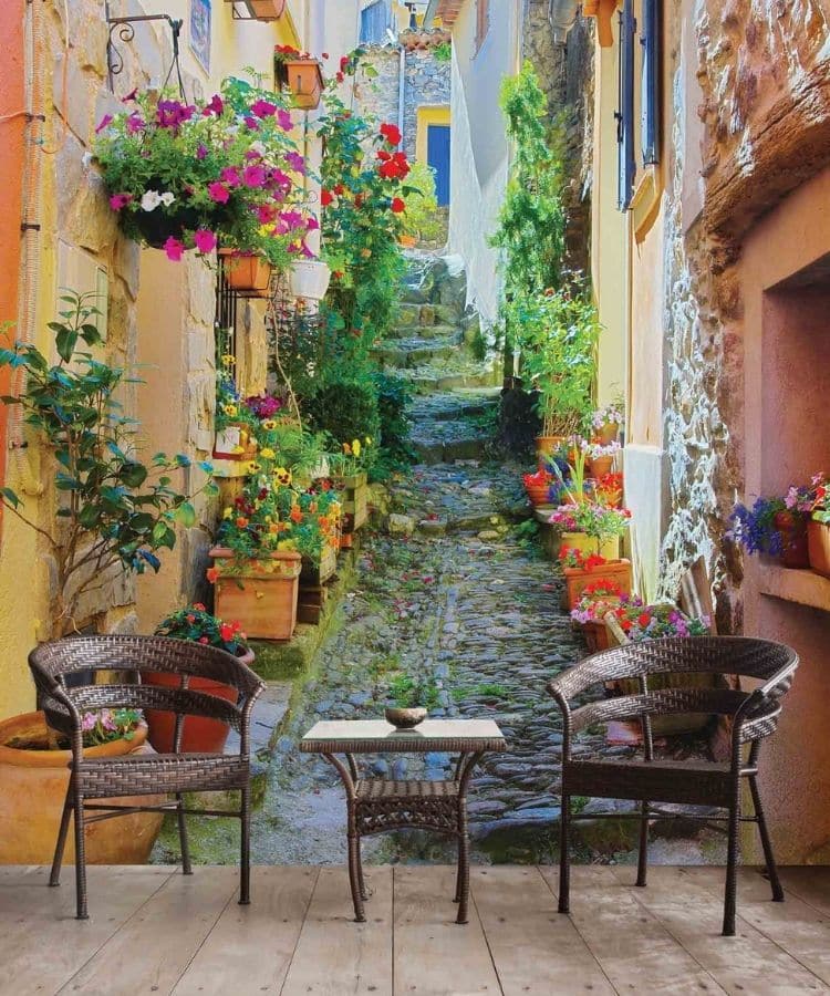 French Village Wallpaper, as seen on the wall of this restaurant, is a photo mural of a flower lined street full of shops in Provence, France from About Murals.