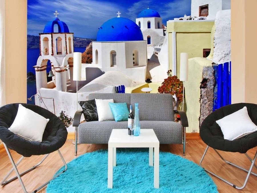 Greece Wallpaper, as seen on the wall of this living room, is a photo mural of 3 blue dome churches in Oia, Santorini from About Murals.