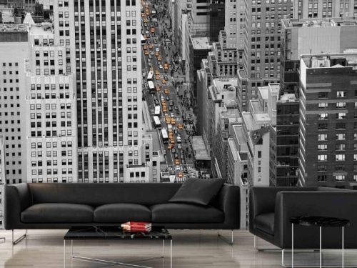 NYC Street Wallpaper, as seen on the wall of this living room, is a black and white photo mural of cars, buses and yellow taxis driving between towering skyscrapers in Manhattan from About Murals.