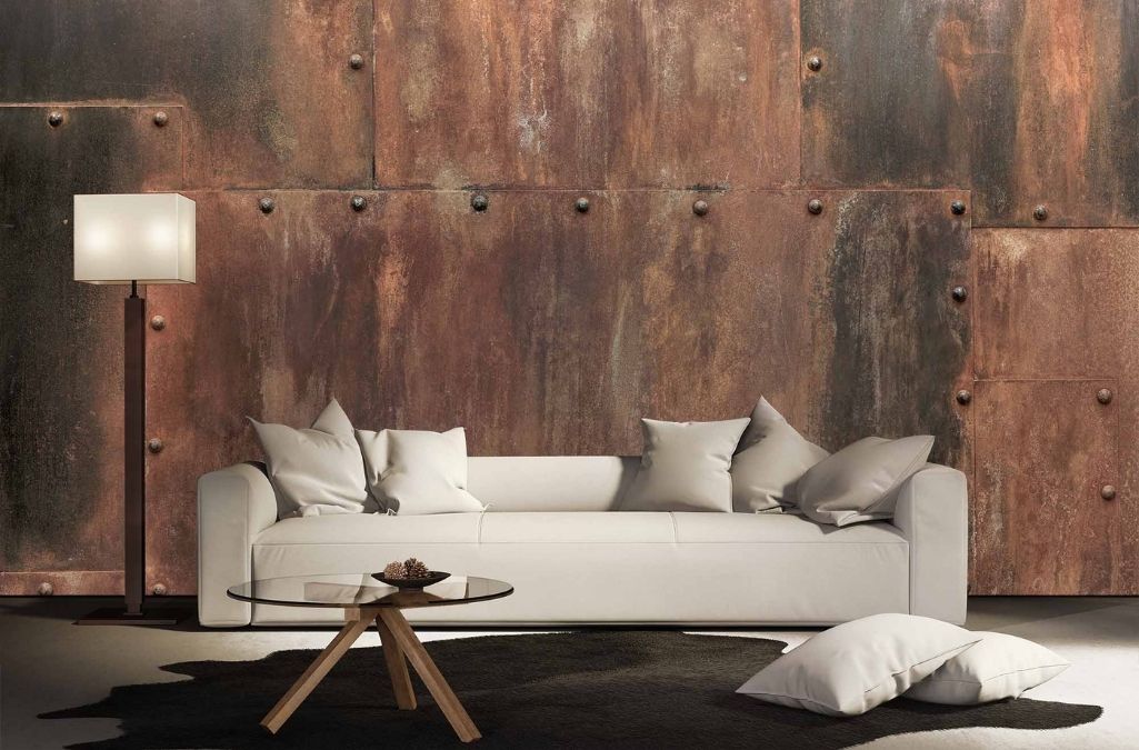 Rusted Metal Wallpaper, as seen on the wall of this living room, features riveted copper metal sheets from About Murals.