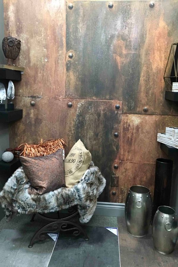 Rusted Metal Wallpaper, as seen on the wall of this retail store, features corroded hammered metal panels from About Murals.