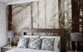 Brown Autumn Wallpaper, as seen on the wall of this bedroom, is a photo mural of sunbeams shining through trees in a forest from About Murals.