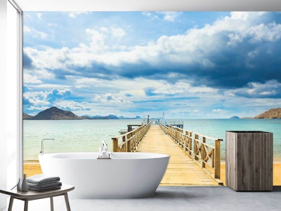 Dock Wallpaper, as seen on the wall of this bathroom, is a photo mural of a wood dock overhanging the blue ocean on a beautiful beach from About Murals.