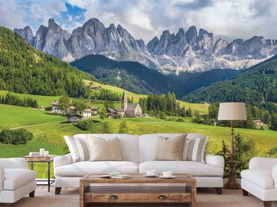 Dolomites Wallpaper, as seen on the wall of this living room, is a photo mural of a church in Santa Maddalena village under Italian mountains from About Murals.