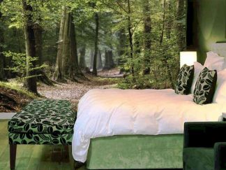 Forest Floor Wallpaper, as seen on the wall of this bedroom, is a photo mural of a leaf covered path winding under green trees in a forest from About Murals.