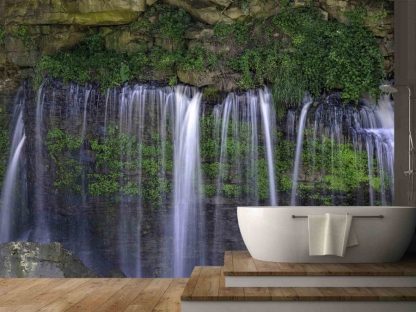 Forest Waterfall Wallpaper, as seen on the wall of this bathroom, is a high resolution photo mural of water showering through a rock crevasse over green foliage from About Murals.
