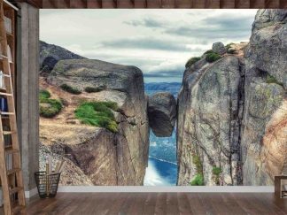 Kjeragbolten Wallpaper, as seen on the wall of this mountain home office, is a photo mural of a boulder wedged between a mountain crevasse in Norway from About Murals.