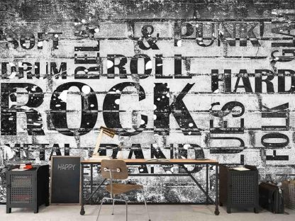 Music Words Wallpaper, as seen on the wall of this rock and roll themed room, is a mural with text like punk, metal, blues, folk, garage and band on a cement block wall from About Murals.