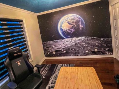 Space Earth Wallpaper, as seen on the wall of this home office, is a wall mural with a beautiful view of the planet earth, as seen from the moon in outer space from About Murals.