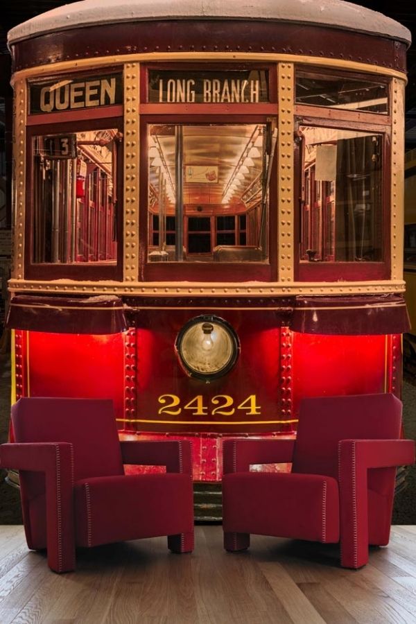 Streetcar Wallpaper, as seen on the wall of this living room, is a photo mural of a red, old Toronto street car from About Murals.