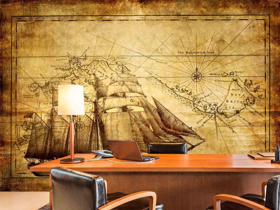 Tall Ship Wallpaper, as seen on the wall of this boat themed office, is a mural with a beautiful antique ship on an old worn map from About Murals.