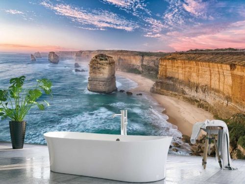 Twelve Apostles Wallpaper, as seen on the wall of this sea theme bathroom, is a photo mural of a sunset over limestone stacks, a beach and the ocean in Australia from About Murals.