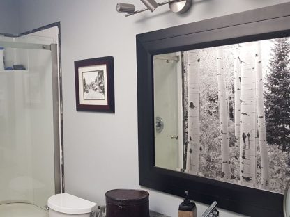 Aspen Wallpaper, as seen on the wall of this powder room, is a black and white photo mural of tall Aspen trees and one pine tree in a forest from About Murals.